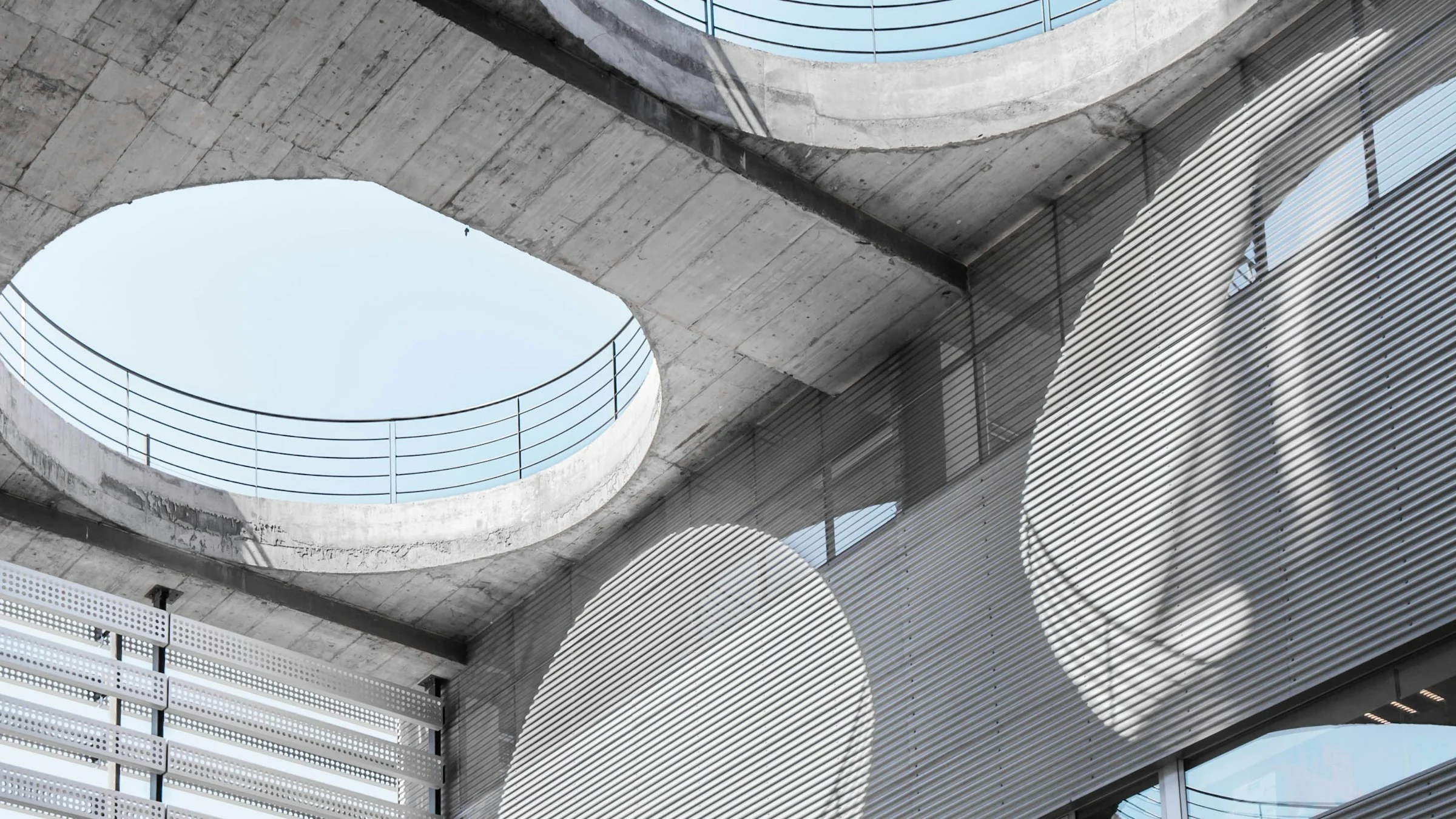 Blick von unten in ein Atrium aus Beton mit runden Oberlichtern