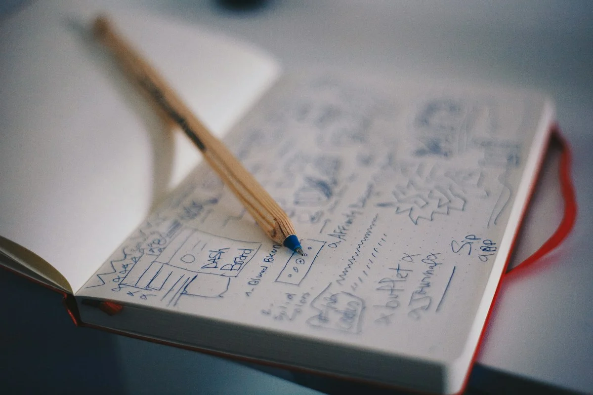 Notizbuch mit handgezeichneten Skizzen und ein Bleistift