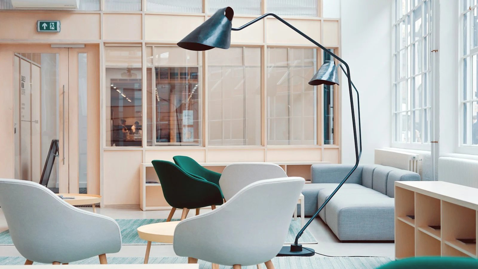 Heller Aufenthaltsbereich mit Sesseln, Sofa und Stehlampe